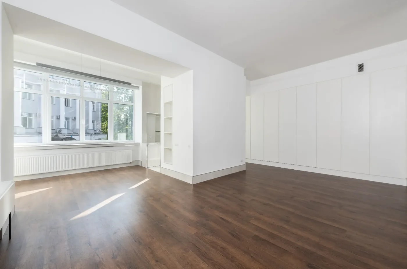 Fertig renovierter Wohnraum mit neuem Holzboden und weiß gestrichenen Wänden